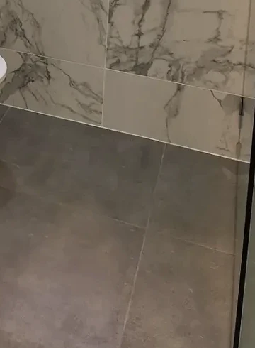 The junction between Bardon’s veined wall tiles and grey floor