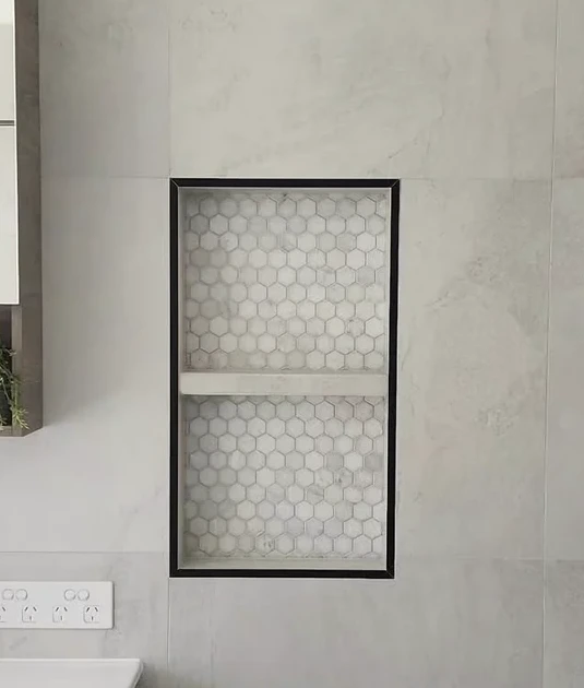 A close-up of the mosaic lining, fitted shelf and dark trim inside the Regents Park niche