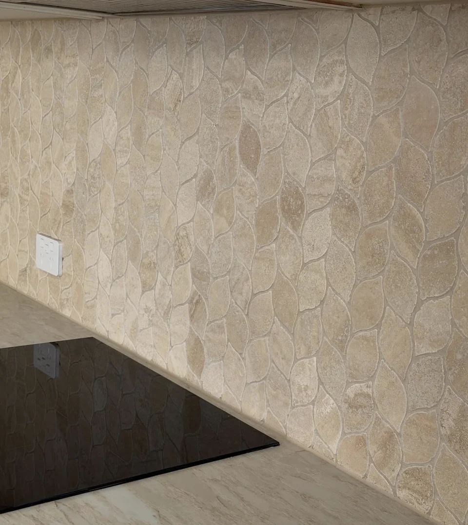 Individual stone shapes fitted into a kitchen splashback with carefully formed grout joints